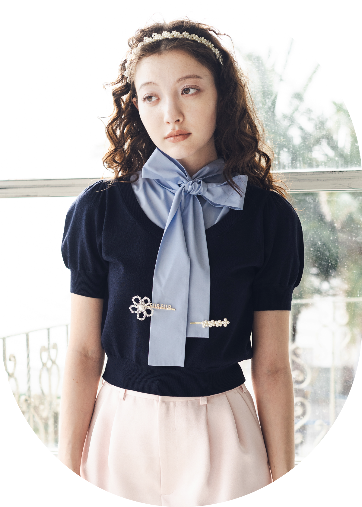 ネイビーのニットトップス・ピンクのスカショーパン・白のフラワーモチーフカチューシャ・ゴールドのフラワーモチーフヘアピンセット・白のシアーリブソックスを合わせたコーディネート