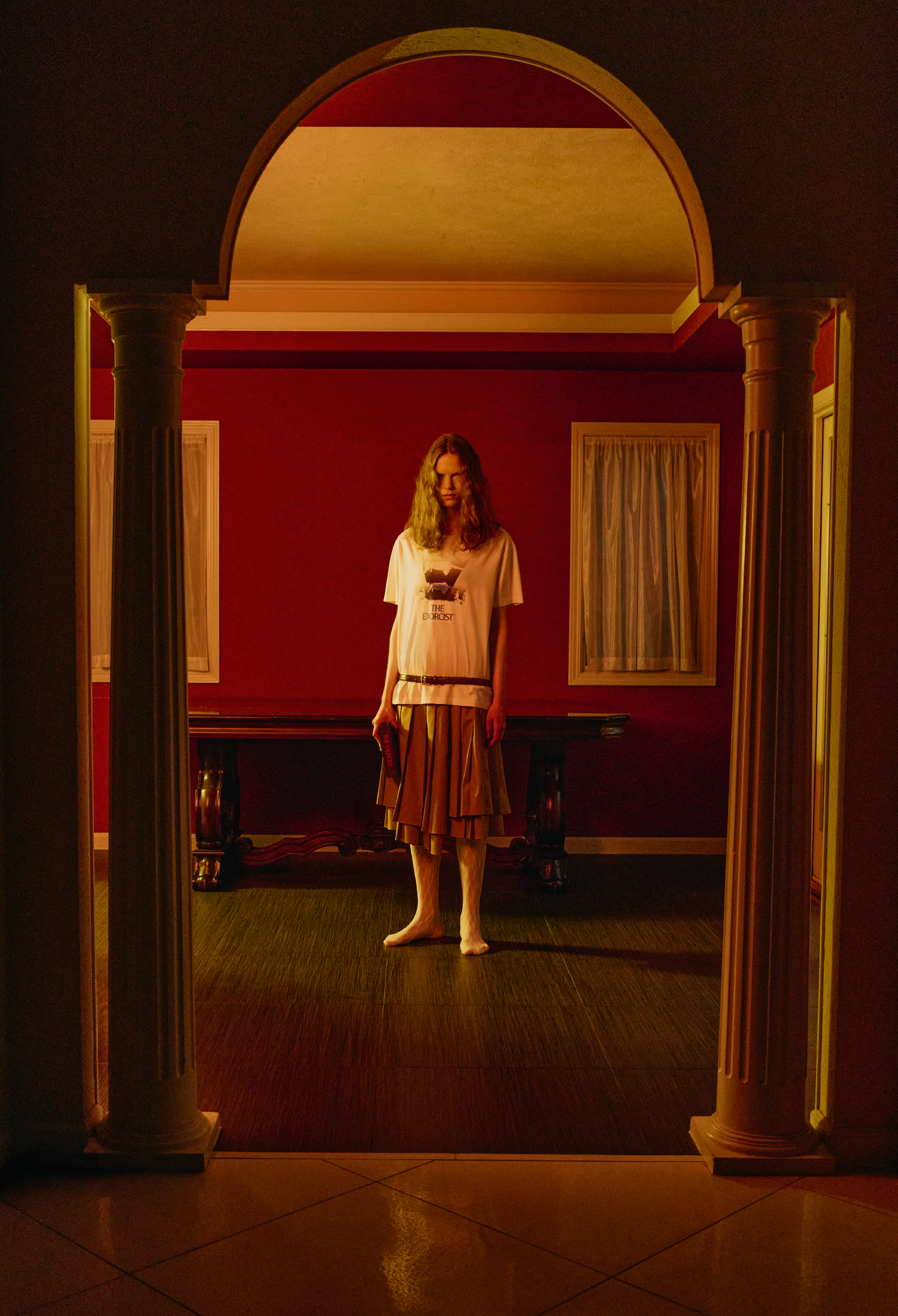 【THE EXORCIST】 グラフィックＴシャツ・レイヤードプリーツスカート・【THE EXORCIST】ブックバッグ・マルチウェイベルトバッグ・レースタイツを着用した女性